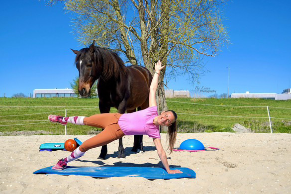 Ruiterfitness instructeur en ruitervitaal coach Sara Tadjipour geeft ruiterfitness naast een paard